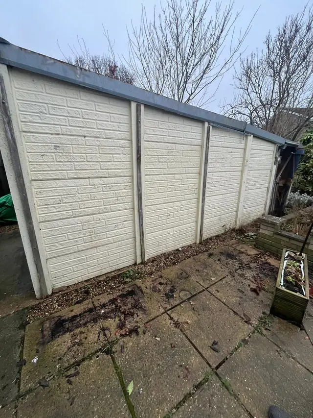Sectional concrete garage with a corrugated roof before it was taken down