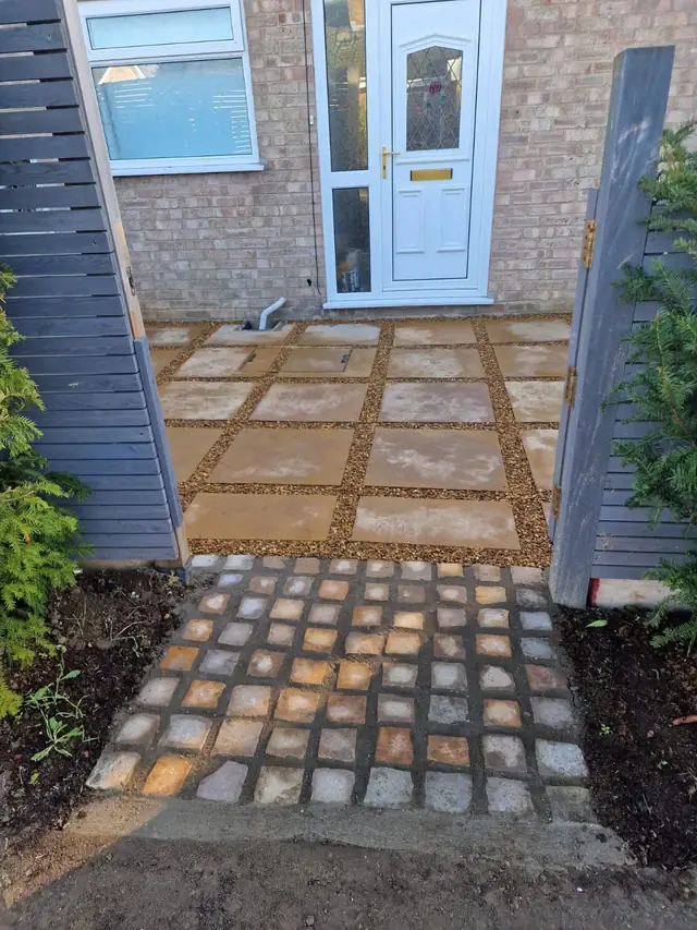 Paved front path with gravel joints and a cobble sett threshold leading to a front door
