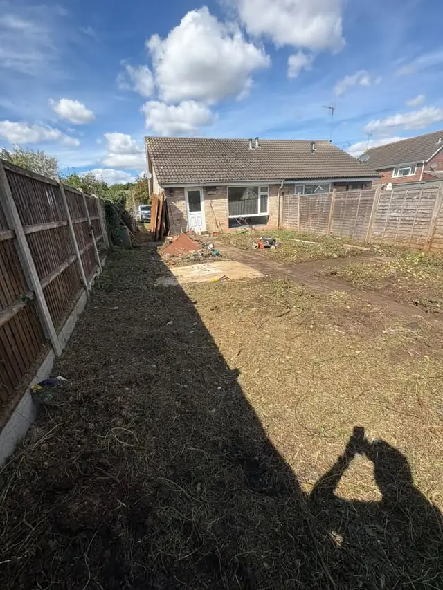 Garden cleared back to bare soil along both fence lines