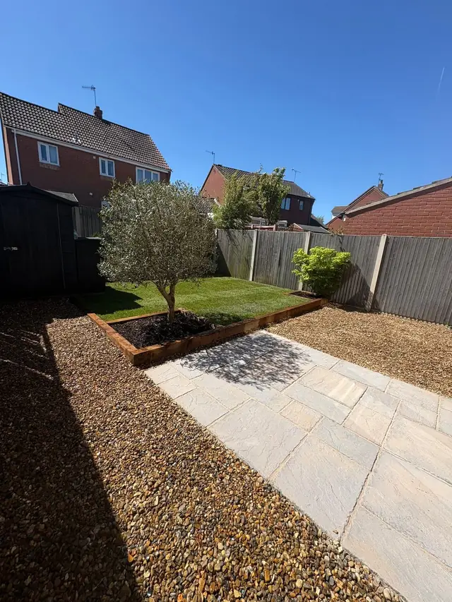 The same garden with a new paved patio, golden gravel, a sleeper-edged bed and fresh turf