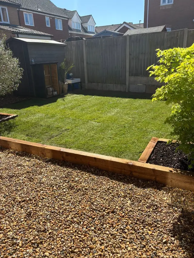Freshly laid turf inside timber sleeper edging next to golden gravel